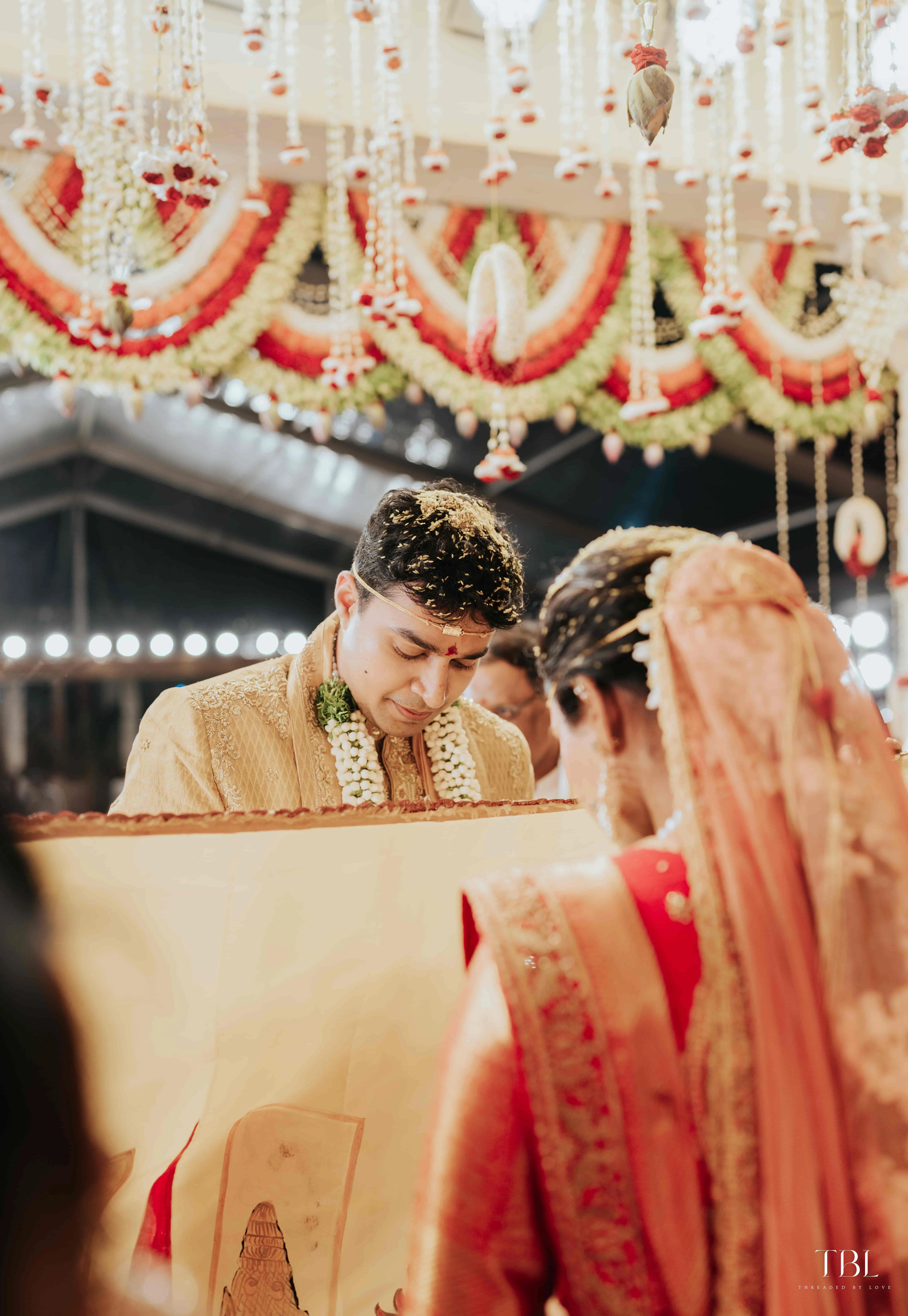 Anusha and Satya posing gracefully inside a beautifully lit venue space during their indoor portrait shoot